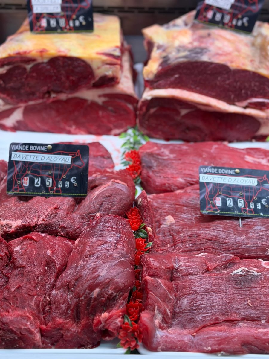 Les bouchers de la Boucherie Dodin derrière leur étal de viandes au marché des Capucins à Bordeaux