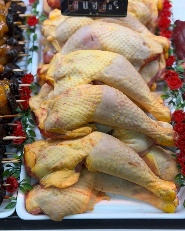 Cuisses de poulet fermier et volaille présentées sur l'étal de la boucherie