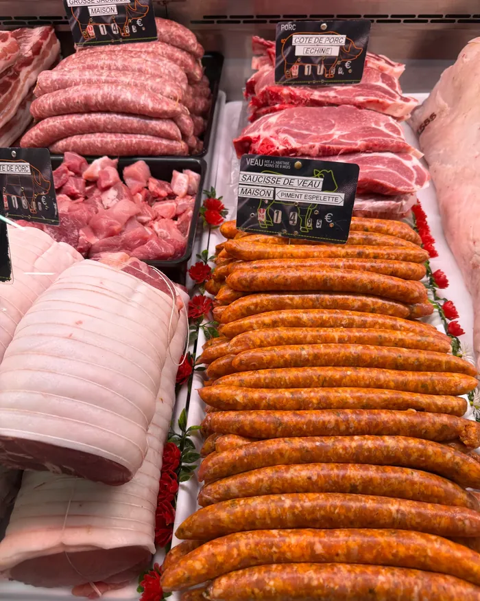 Chipolatas, merguez et poitrine roulée dans la vitrine de la boucherie